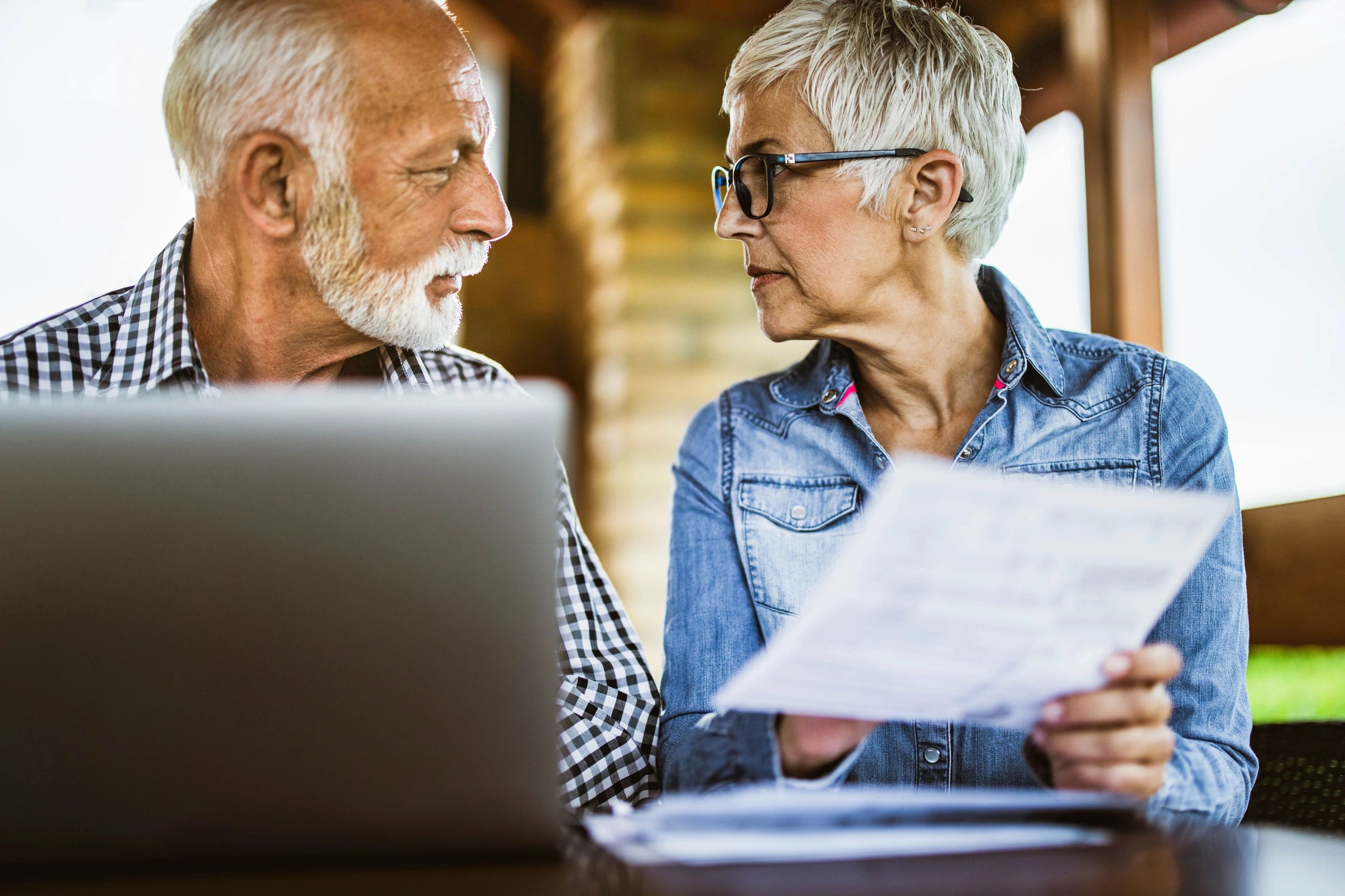 Mature couple reviewing finances on a laptop