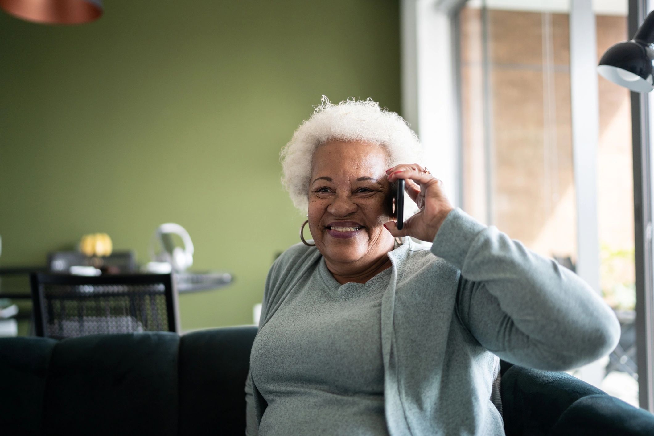 Senior woman speaking on the phone at home