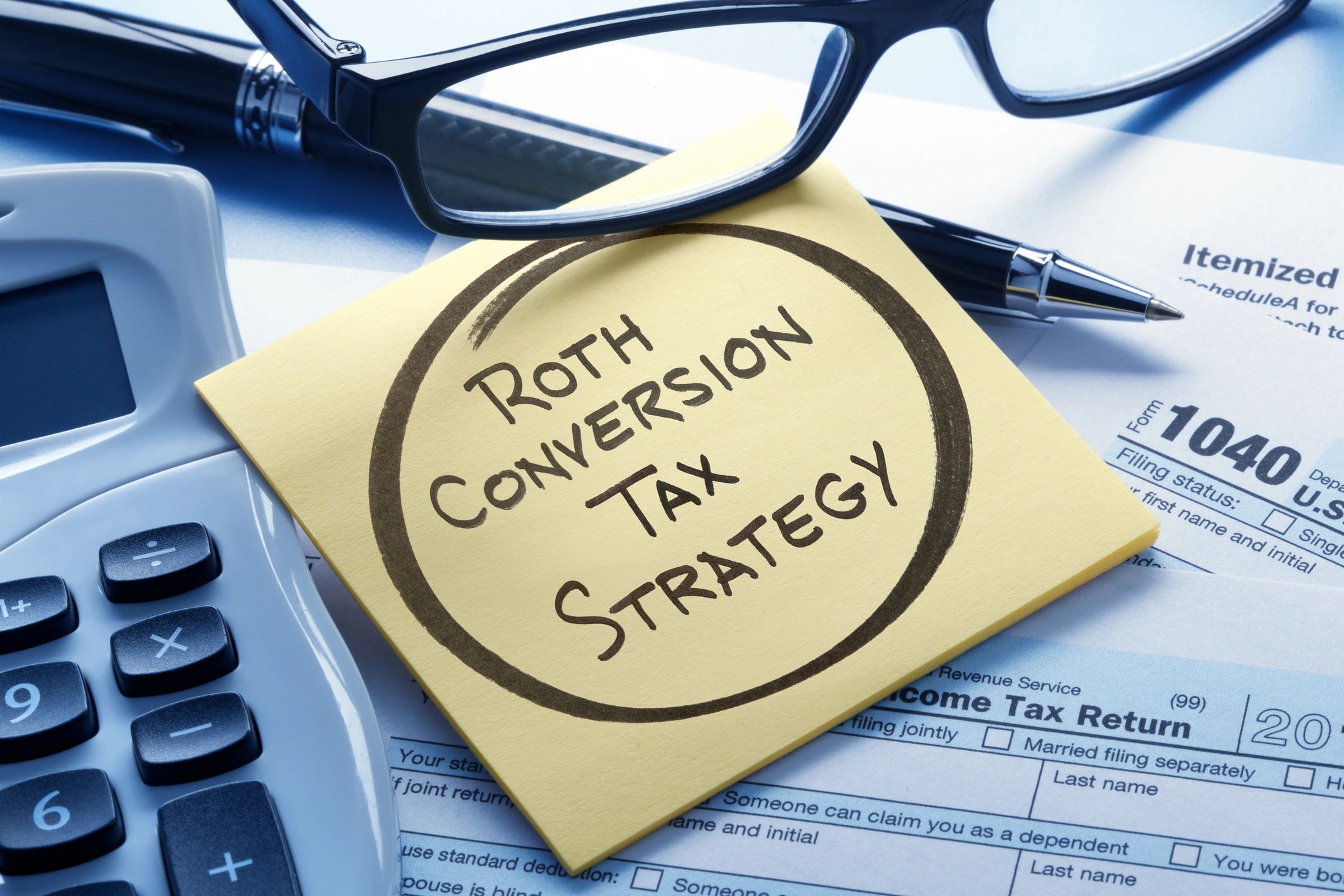 Tax planning notes on a notepad next to a calculator