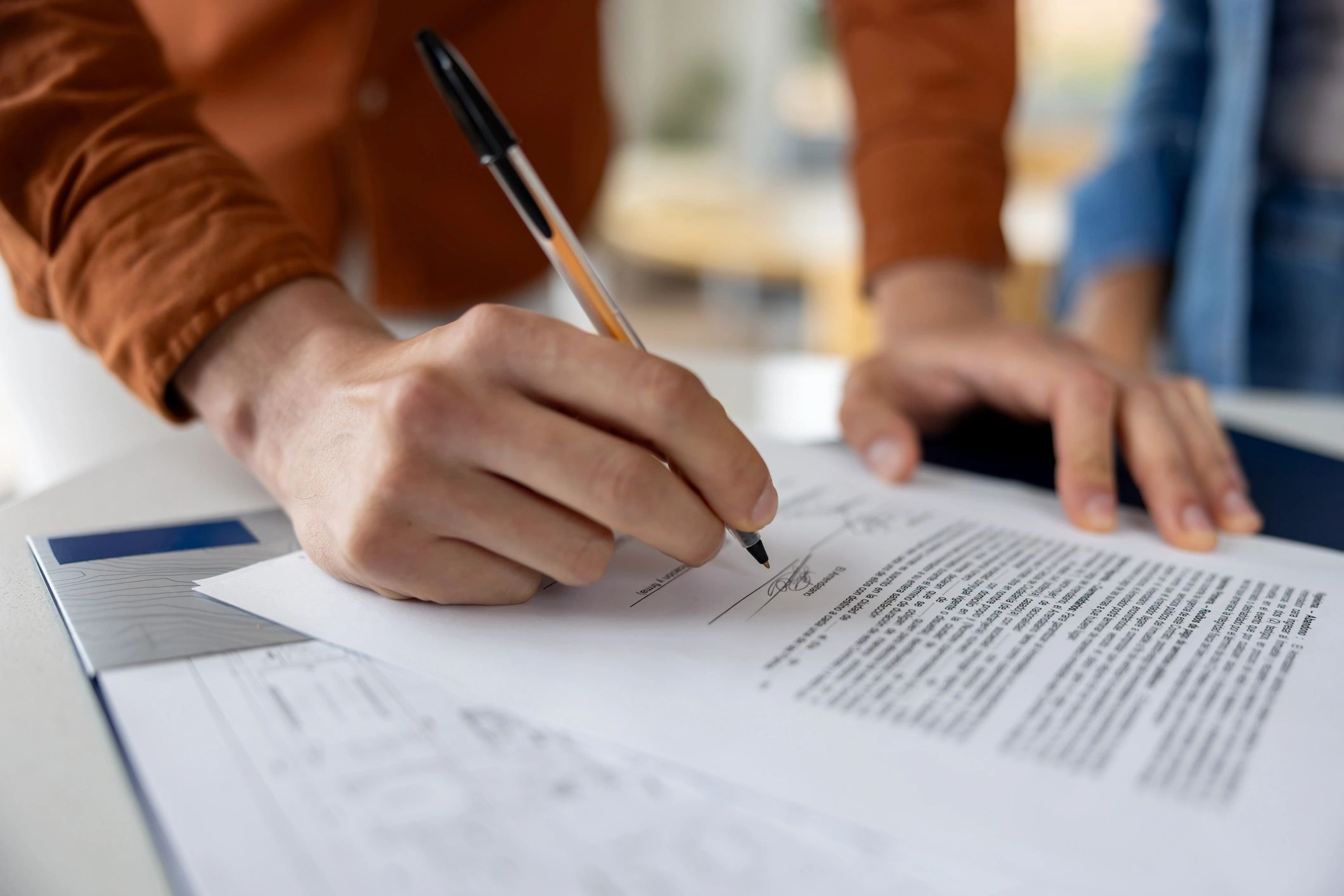 Hands signing paperwork